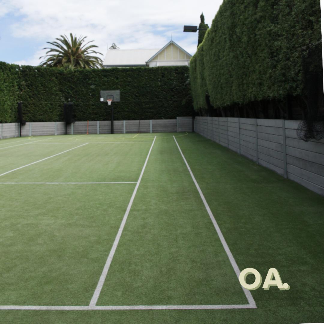 Walled grass court after, clean and green with bright lines
